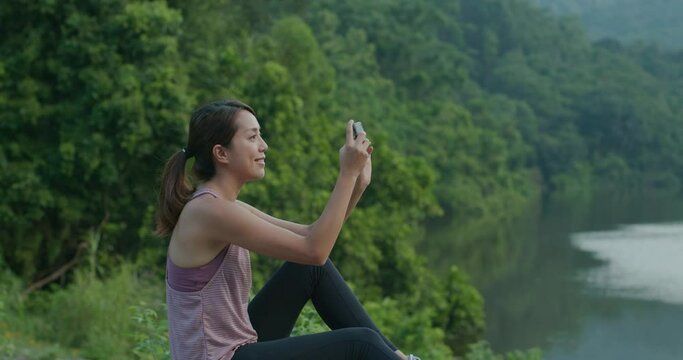 Sport woman use cellphone to take photo at countryside