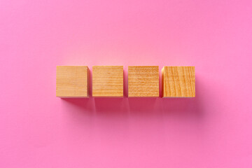 Top view of toy wooden blocks on pink