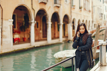 Fototapeta na wymiar girl talking on the phone and taking pictures in Venice Italy