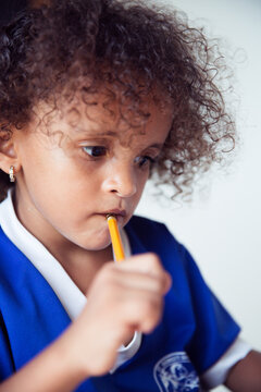 Young girl with curly hair doing homework