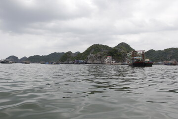 Fototapeta na wymiar HA LONG BAY, VIETNAM - March 13, 2020: Halong Bay, Vietnam. Unesco World Heritage Site. Traditional tourist boats.