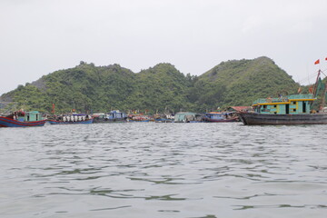 Fototapeta na wymiar HA LONG BAY, VIETNAM - March 13, 2020: Halong Bay, Vietnam. Unesco World Heritage Site. Traditional tourist boats.