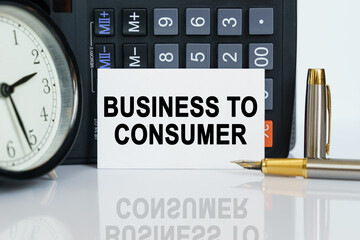 On the table there is a clock, a pen, a calculator and a business card on which the text is written - BUSINESS TO CONSUMER
