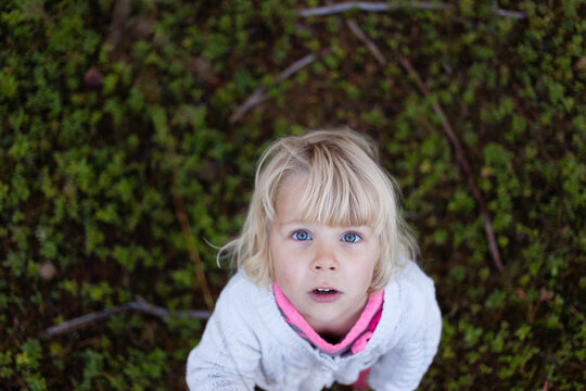 Cute girl looking up straight in the camera.