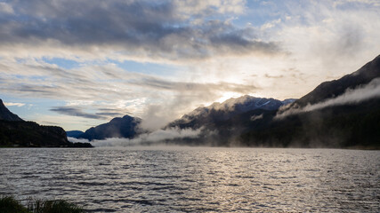 Maloja mountain Pass, Switzerland. Landscape of the lake Sils in the morning during the fall time. The fog covers the lake and the shores. Traditional Swiss contest. Natural landscape