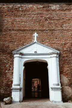 Fototapeta Side entrance to a centuries old Catholic church made of red bricks and limestone.