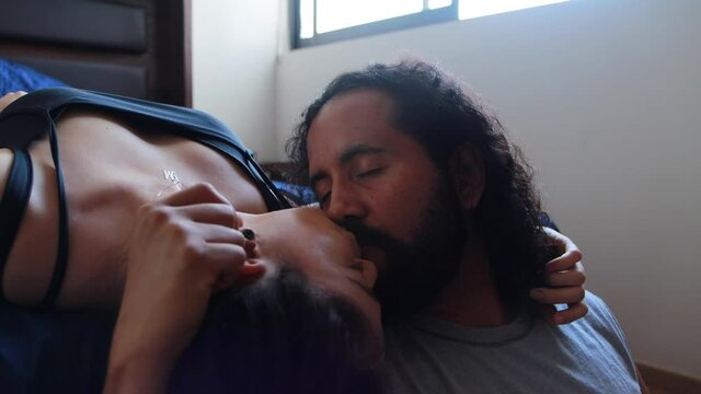 Pareja de j&oacute;venes mexicanos platicando en cama muy cerca amorosos beso relaci&oacute;n