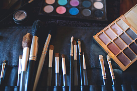A palette of colourful eye shadows and brushes