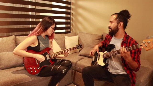 Pareja joven latina mexicana tocando musica juntos en sala