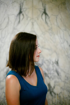 profile of woman in front of marble wall