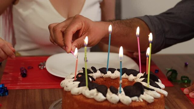 Detalle de pastel de cumplea&ntilde;os prendiendo las velas pidiendo un deseo