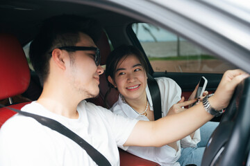 Couple traveler sit inside a car using map application on smartphone.