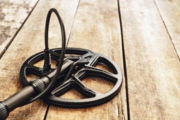 Metal detector tool on wooden board close up