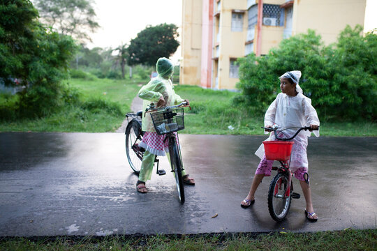 Teenagers wearing rain proof and gossiping on road