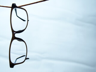 紐に吊るされたセルフレームのメガネ