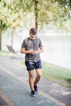 Teenager playing location-based augmented reality game on his smartphone in the city