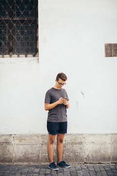 Teenager playing location-based augmented reality game on his smartphone in the city