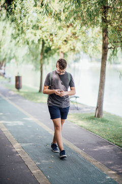 Teenager playing location-based augmented reality game on his smartphone in the city