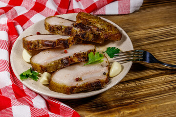 Baked pork belly in a plate on wooden table