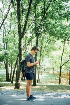 Teenager playing location-based augmented reality game on his smartphone in the city