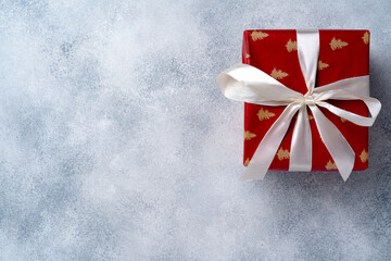 Red Christmas gift box on grey frosted background