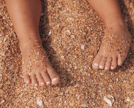 children's feet on the sea sand