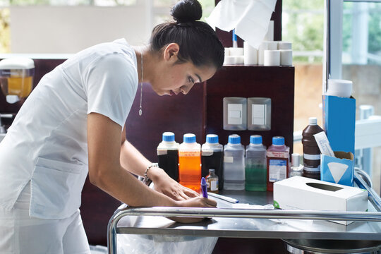 Female nurse writing notes at nurse's station