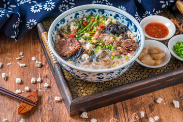 A bowl of Shaanxi Xi'an delicious mutton steamed bun on a wooden table