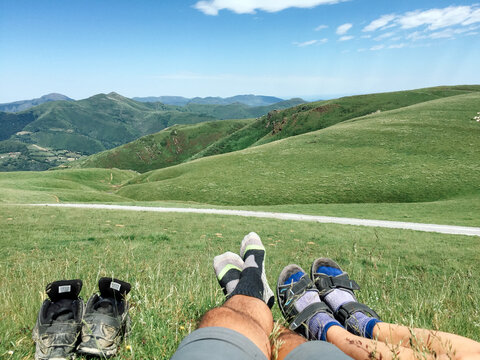 Two hikers barefoot relaxing on the grass