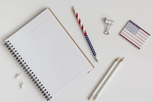 Open blank notebook, stars and stripes pencil and other office utensils