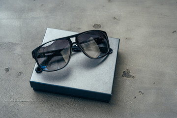Dark male sunglasses on grey concrete surface