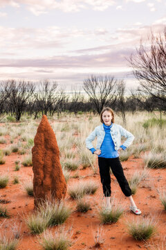 tween girl standing next to termite mound in outback NT, Australia