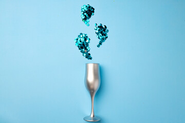 Champagne glass with confetti flat lay top view