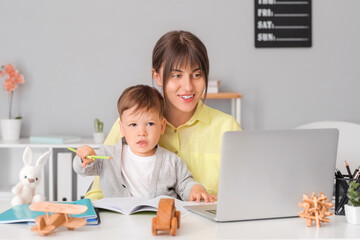 Working mother with little son in home office
