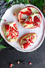 pomegranate red fruit sweet on the table and a twig of green christmas tree new year tasty treat serving size top view copy space for text food background rustic food background rustic