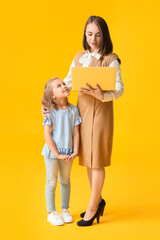 Working mother with little daughter on color background