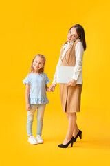 Working mother with little daughter on color background
