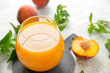 Glass of fresh peach juice on table