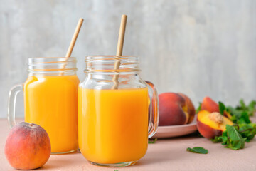 Mason jars of fresh peach juice on table