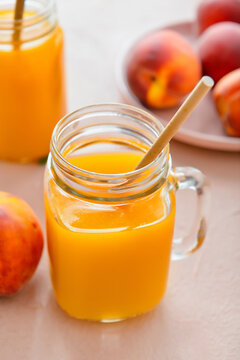 Mason jar of fresh peach juice on table