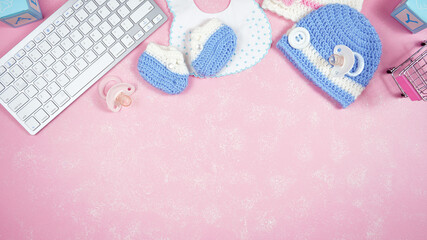 Baby nursery clothing mom bloggers desktop workspace with pink and blue accessories on stylish pink...