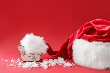 Santa hat and Christmas decor on color background