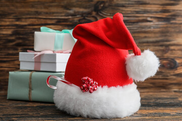 Obraz na płótnie Canvas Santa hat and Christmas gifts on wooden background