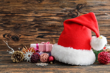Santa hat and Christmas decor on wooden background