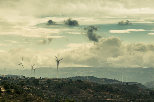 Mountainous landscape with electric windmills on a stormy day..