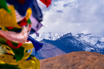 Colorful prayer flags flying in winds with Himalayas mountains at Komic village of Spiti Valley,  Himachal Pradesh, India.