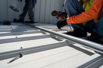 worker wear all safety suit insatlling metal frame on rooftop stock photo