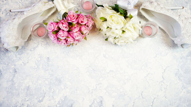 White aesthetic wedding bridal theme desktop workspace with high heel shoes, bouquets and accessories on stylish white textured background. Top view blog hero header creative composition flat lay.
