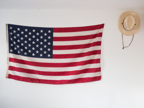 American flag and straw hat hanging on wall of bedroom as decoration