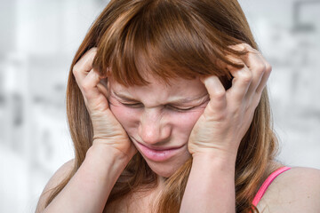 Woman with headache or migraine is holding her aching forehead